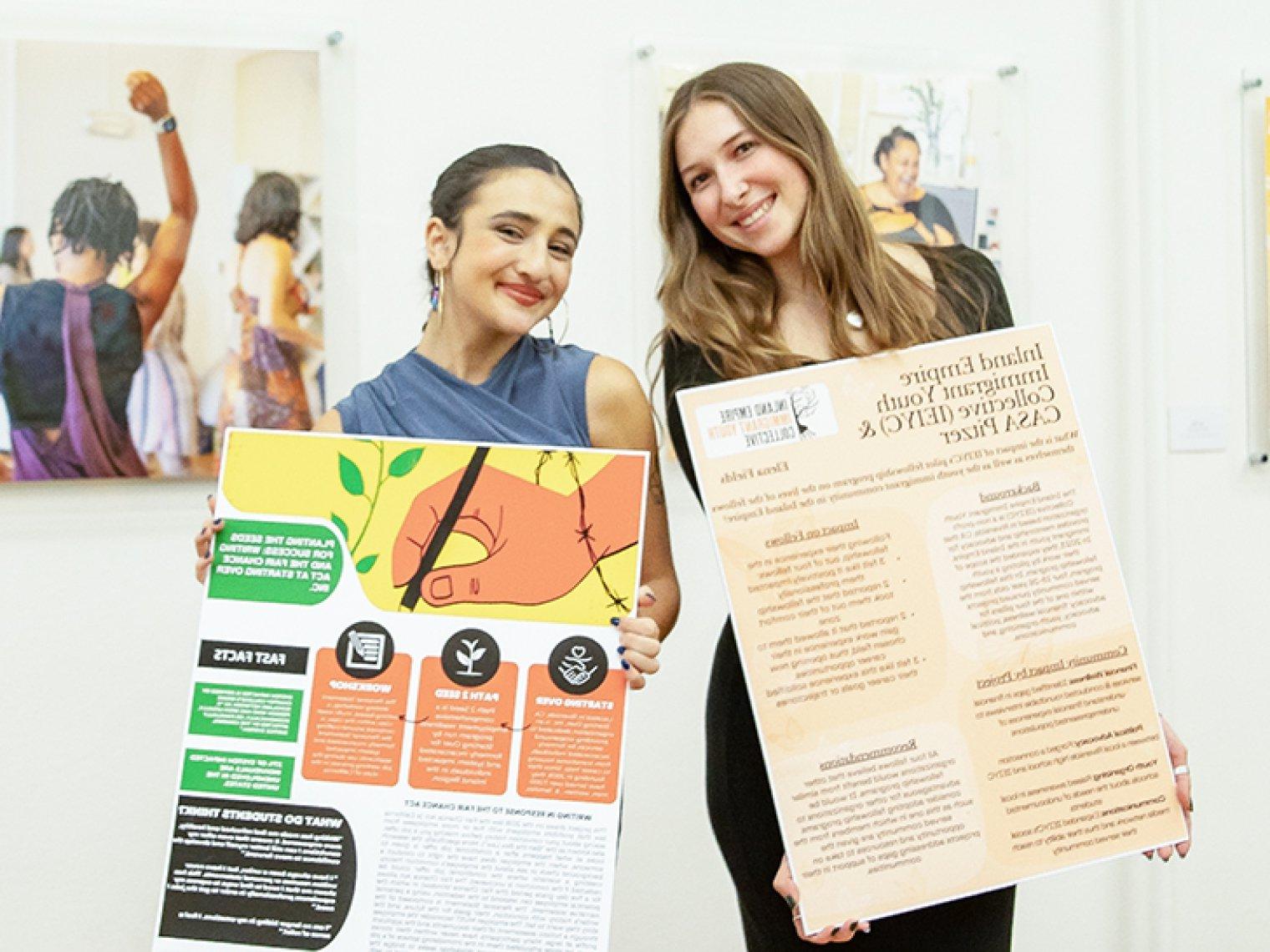 students hold up their research posters